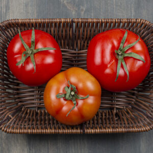 Fresh juicy tomatoes in a wicker basket . High quality photo